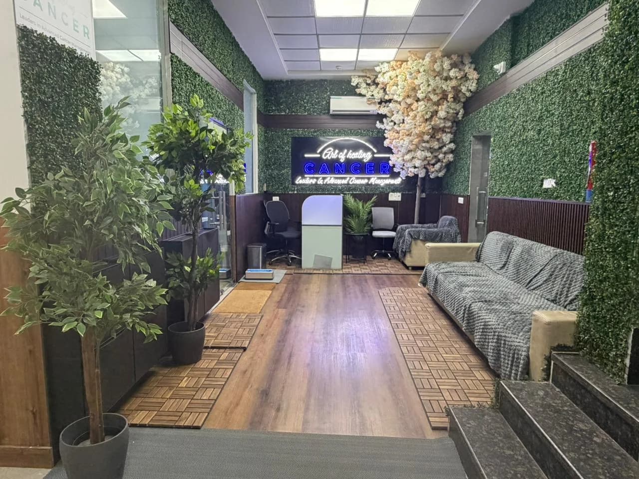 Reception and family waiting lounge at the Art of Healing Cancer centre, with living green walls and warm seating